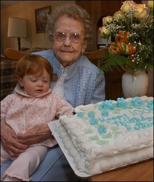 Ella Snyder, 1, has her eyes on the cake of her great-great grandmother, Ester Evenson, at her 100th birthday party.