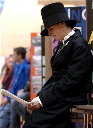 NBR camp23p    Dilon Williams a 8th grader at   East Toledo Junior High, looks over some papers in  the schools gym while waiting in his booth Saturday 4/23/05  morning.  Outside activites of the Civil War were rather damp due to the rain.  The Blade/Madalyn RUggiero