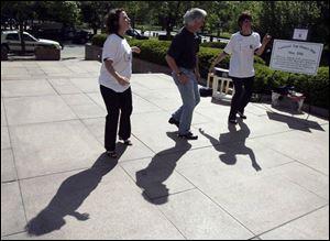 Gale Mentzer, left, Dan Madigan, and Brenda Michalak celebrate National Tap Dance Day outside Government Center. The day became law in 1989. Toledo has not celebrated it.