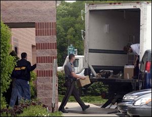 Investigators and Ohio Highway Patrol officers load a truck with materials confiscated from rare-coin dealer Tom Noe's shop in Monclova Township Thursday.