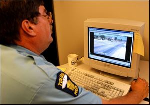 Toledo Police officer Ed Petersen studies images of cars and their license plates caught on camera committing traffic violations at Monroe Street and Secor Road.