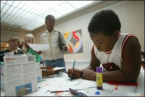 Deonte Hill and his sister Shawnta finish work at the Toledo Museum of Art on a paper square for a quilt that celebrates freedom. The quilt will be displayed at the museum.