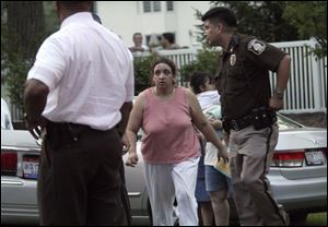 Lisa Sahadi Ali, daughter of Alexander and Theresa Sahadi, is
escorted to her parents  home, the site of the fatal shooting.
