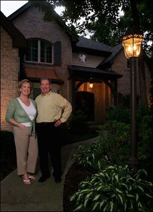 Katie and Steve Branam outside their Sylvania home, which is landscaped with lighting
fi xtures to accent their grounds after the sun goes down.