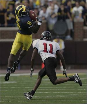 Michigan's Jason Avant caught nine passes for 127 yards, including this one against Northern Illinois defender Alvah Hansbro.