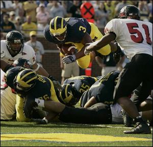 Michigan freshman Kevin Grady, who rushed for 42 yards, dives into the end zone late in the first half. The Wolverines compiled 447 total yards but allowed 411.