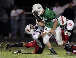 Stritch defenders Brian Gerrier, left, and David Crozier bring down Ottawa Hills  Nasri Hajjar.
