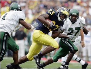 Michigan's Max Martin runs through EMU's Duane Bracy, left, and Jereme Perry to his 2nd TD.