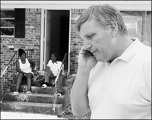 With Shanika Gettridge in the background, John Nail speaks on his phone. Mr. Nail was prompted in his search for family members after he read a Pittsburgh Post-Gazette article.
