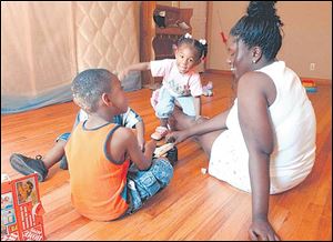 Shanika Gettridge can find joy in the play of her children, 2-year-old twins Chrishelle and Christopher, and Joseph, 4, at her Decatur, Ga., home, now that her family is together.
