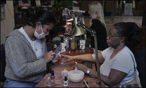 Diem Anderson tends to regular customer Martha Crawford at California Nails in Franklin Park. 