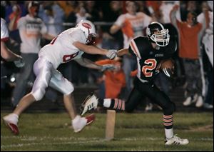 Otsego s Justin Henck pulls away from an Eastwood defender to score a touchdown on a 20-yard run in the third overtime period.
