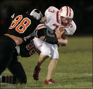 Eastwood quarterback Eric Rutherford is sacked by Otsego defenders Eric Zuhlsdorf (88) and Justin Southwick in the second quarter. Zuhlsdorf later caught
the gamewinning touchdown pass in the fifth overtime.
