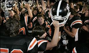 Otsego players, including backup quarterback Andy Cocke, bottom center, celebrate the Knights' five-overtime victory.