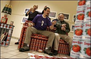 Members of a team from The Collaborative Inc. sit on their can design, titled 'TV Dinner,' at SeaGate Convention Centre.