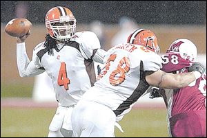 Bowling Green quarterback Omar Jacobs looks to throw over blocker Rob Warren and Miami's Craig Mester.