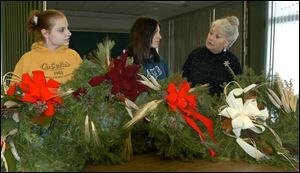 Lenawee County Vo-Tech Center instructor Pam Meinke
discusses Williamsburgstyle holiday decorations with
Courtnie Chappel.