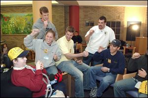 David Schoonover (back, in white shirt) and friends sing the Michigan fight song with Kenny Winder, 12.