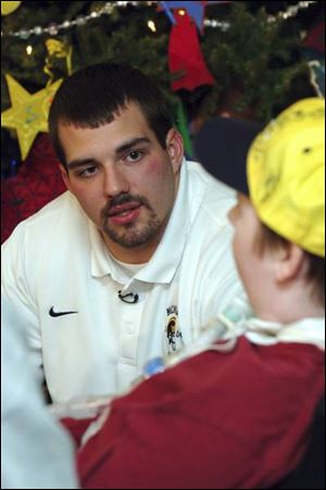 Michigan offensive lineman David Schoonover, left, talks to Kenny Winder. Schoonover has visited Mott Children's Hospital weekly for five years.