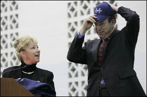 Pamela Campbell, superintendent of the Montpelier Exempted Village Schools, watches as Gov. Bob Taft tries on a cap during a dedication ceremony for the area's new school. The 173,000-square- foot building will house students in all grade levels beginning this week. The school will replace three older facilities in the district.