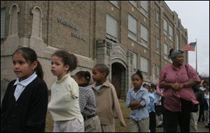 Students wait outside Sherman Elementary School as smoke from two small blazes is expelled. The fires started nearly simultaneously in two boys' restrooms. 'We believe that it's a student who did this,' Toledo Public Schools chief of staff John Foley said. After 30 minutes, the children were moved to portable classrooms and TARTA buses.