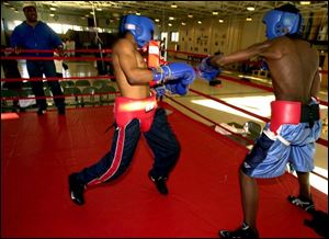 Henry Moore, left, is a trainer in the Police Athletic League boxing program.
