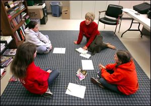 Clockwise from lower left, Brooke Tullis, Ashley Smith, instructor Beth Wagoner, and Hannah Cheetwood discuss a book in one of 14 groups that study reading at Gateway Middle School.
