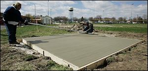 Brenda Orcelletto, owner of M&B Concrete LLC, and Tim Kazmierczak work on a discus pad.