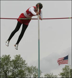 Ryan McKibben of Eastwood clears the bar at 14 feet, 6 inches to win the pole vault event yesterday in the Suburban Lakes League track and field championships at Eastwood. McKibben set a new meet record with his effort. The Eagles boys and girls teams have both won six straight league championships.