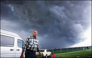 Brice O Daniel watches approaching storm clouds in the
parking lot of Evergreen High School in the Fulton County
town of Metamora. Severe thunderstorms tore across much
of northwest Ohio and southeast Michigan yesterday, triggering
wind gusts exceeding 60 mph and showers of hail in some areas. In Indiana, storms spawned at least one suspected tornado in Pike County, about 50 miles southwest of Bloomington, and uprooted trees. 