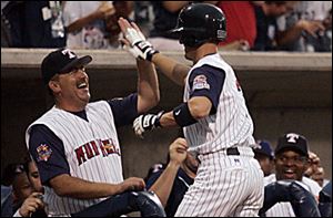 Mud Hens pitching coach Jeff Jones greets Ryan Raburn after Raburn hit a home run n the seventh inning for the International League in last night's Triple-A All-Star game.