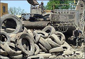 Ohio EPA Tires are loaded into a shredding machine at the Kirby tire dump in May. State environmental officials say the cleanup of the Sycamore, Ohio, dump will be finished this year, eight years ahead of schedule. But millions in fines remain uncollected. About 19 million tires have been removed so far.