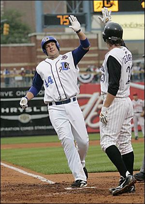 Kevin Witt, a former Mud Hen who now plays first base for the Durham Bulls, high-fives Louisville's Chris Denorfia (20) after hitting a two-run homer in the third inning to help get the International League off and running to a Triple-A All-Star win.