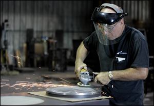 Joe Ward grinds a structural part for a bridge at D.S. Brown's factory in North Baltimore. 