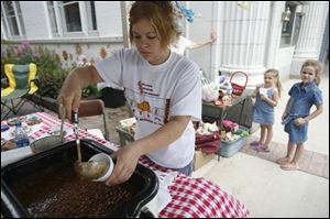 Lauren Pringle of Ace Equestrian Therapy scoops out beans for Trinity Saxton, 3, back left, and Davina Eitniear, 6.