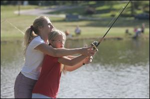 Renee Schafer and daughter Tabitha Schafer, 8, cast a line into the pond.