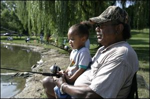 James Hague, 2, and his grandfather Hiram McFarlin keep an eye out for a possible nibble at Sleepy Hollow Park on Dorr Street.
