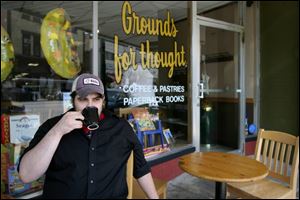 Mark Peterson of Bowling Green enjoys a cup of coffee outside Grounds for Thought on Main Street. 
