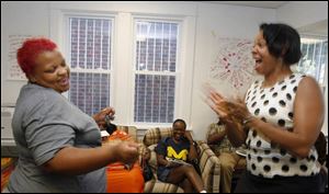 Student Ikentina Haynes, left, dances with Crystal Harris, before the start of class in the Bridges Out of Poverty program.