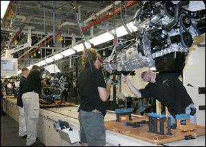 Workers verify the transmission and engine fit at the chassis assembly plant run by a subsidiary of Hyundai Mobis. 