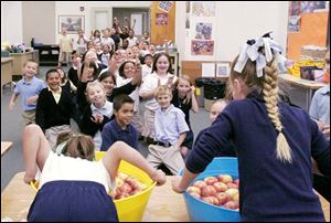 Kayla Willier, 9, left, and Paige Olic, 8, are cheered as they bob for apples on Peter Navarre Day.