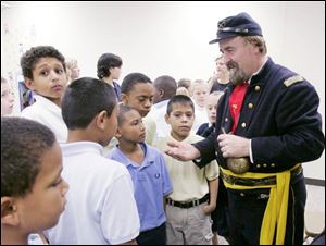 Re-enactor Neil Buttermore shows some black powder to some of the fourth graders.