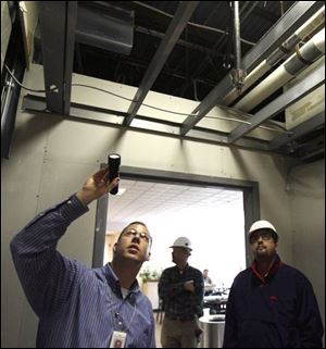 Inspector Aric Alexander, left, with the state fire marshal's office, examines the work that has been completed at Mercy Memorial Hospital in Monroe with Paul Micallef, right, a contractor's representative. 