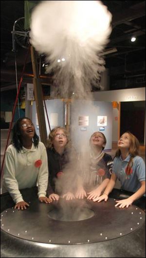 From left, Candice Patterson, 11, of Garfield Elementary School, Andrew Finelli, 11, of Raymer Elementary School, Troy McCown, 12, of Garfield, and Ashley Bryant, 12, of Raymer play with the smoking ring at COSI. The children's science museum is seeking its first tax funding with Issue 11 on Tuesday's ballot. The Toledo Zoo also is seeking
tax funds with Issue 13, a 10-year capital improvement levy.