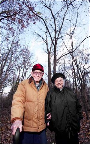 Gerald and June Meyers are dwarfed by the whopper of a locust tree behind them. It is 103 feet tall and measures 155 inches around. This is the third time they've won in the last four years.