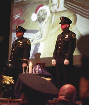 Findlay Police Sgt. David Hill, left, and Patrolman Brad Doolittle stand at attention during the memorial service for Flip, the department s K-9 officer, who was shot to death Nov. 18.