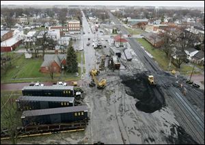 Cleanup work continues at the site in downtown North Baltimore where 20 cars from two freight trains derailed Thursday.