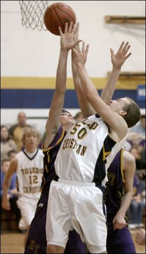 Kyle Whitlow goes up between two Holgate defenders to try for a rebound. Whitlow came off the bench to score 12 points.