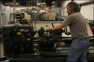 Machinist Mark Bice, right, makes a part in the machine shop of Projects Designed & Built Inc. in North Toledo.