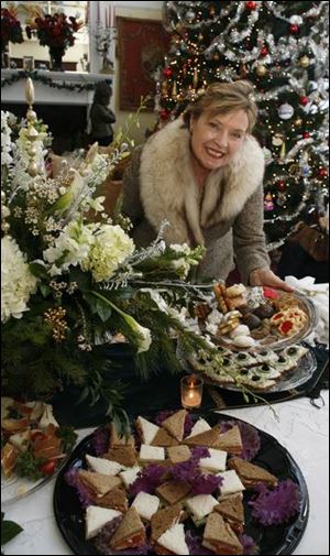 Diane Rusk Disbrow with some of the desserts served at the Opera Guild's holiday tea in the home of Tom and Traci Schwann.